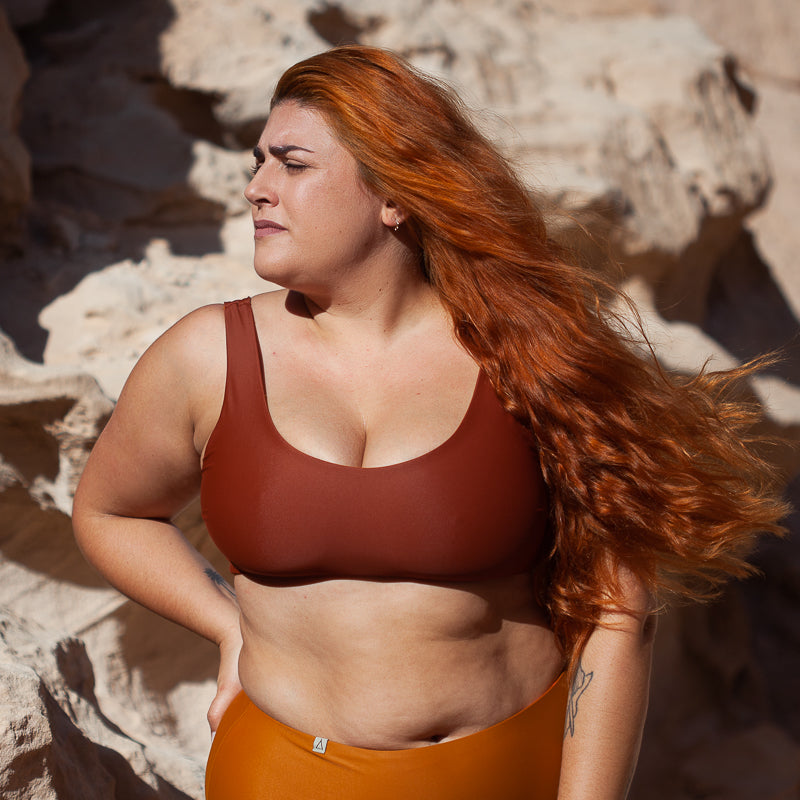 Frau mit Bikini Oberteil in Ocker schaut nach links
