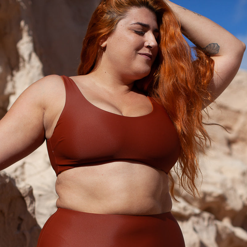 Vordere Seitenansicht einer Frau mit dem Bikini Oberteil in Ocker