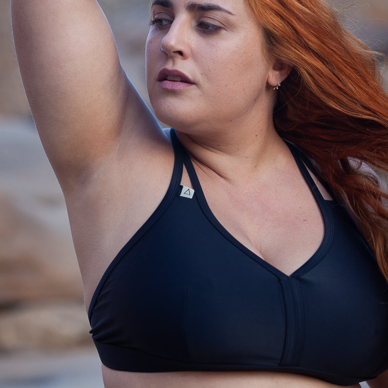 Frau trägt schwarzes Sportbikini Oberteil WILD in Schwarz