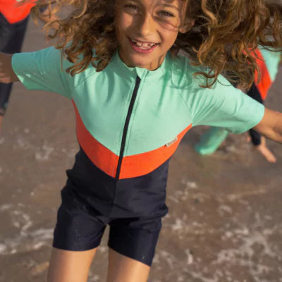 Lachendes Mädchen mit dem INASKA Kinder UV-Badeanzug